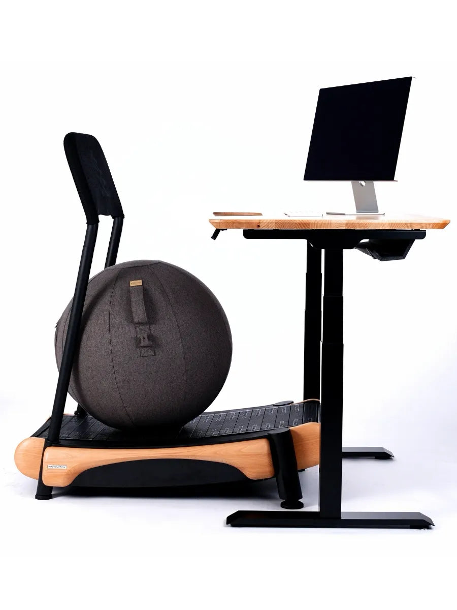 A modern Walkolution workstation includes a wooden treadmill, the Walkolution Active Sitting Ball with backrest for ergonomic seating, an adjustable desk with monitor, and a clean white backdrop.