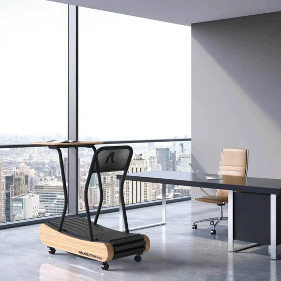 A modern office with large windows overlooking a city skyline. In the room are a sleek desk with a chair and a stylish black treadmill desk on wheels with a wooden base.