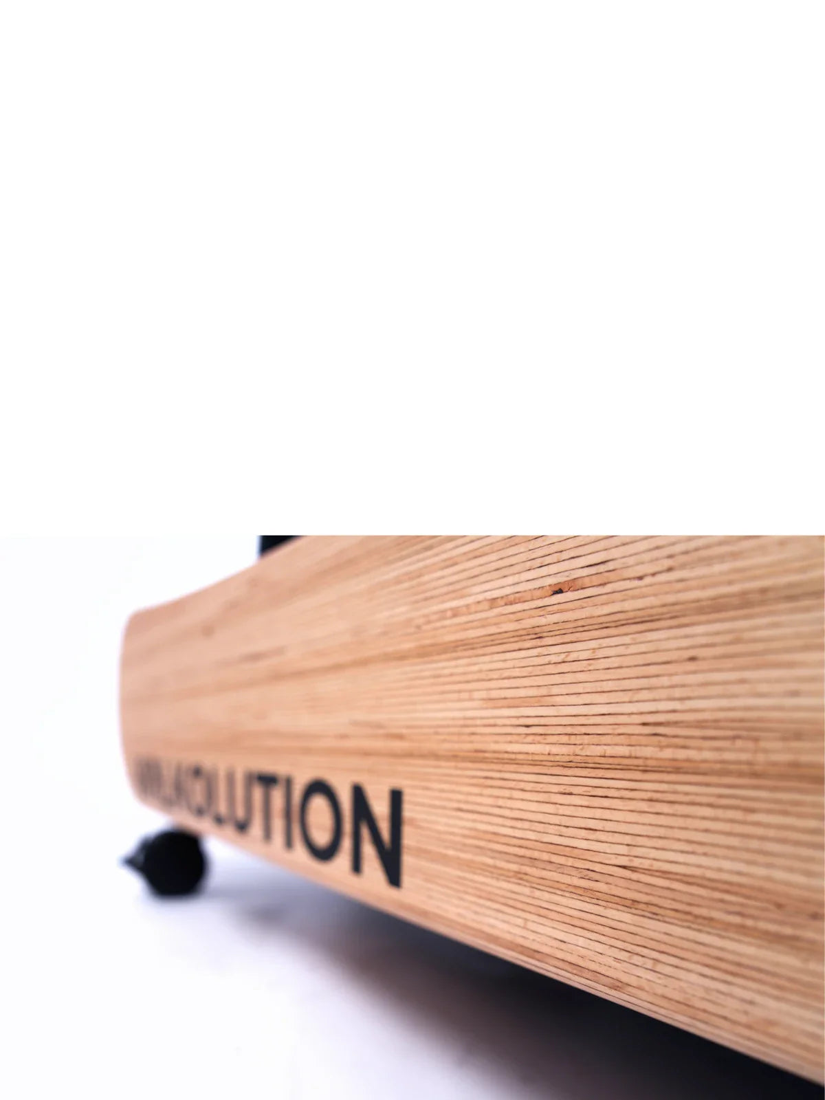 A close-up of the curved wooden edge of the Walkolution 1 walking desk, showing visible wood grain and part of the word EVOLUTION in black letters on the side against a mostly white background.