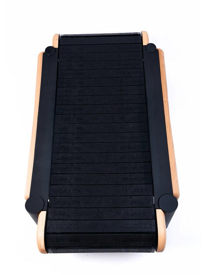 A top view of the Walkolution 2, a motorless office treadmill with a compact curved black running surface and wooden side frames—ideal for walking while you work—all shown on a white background.