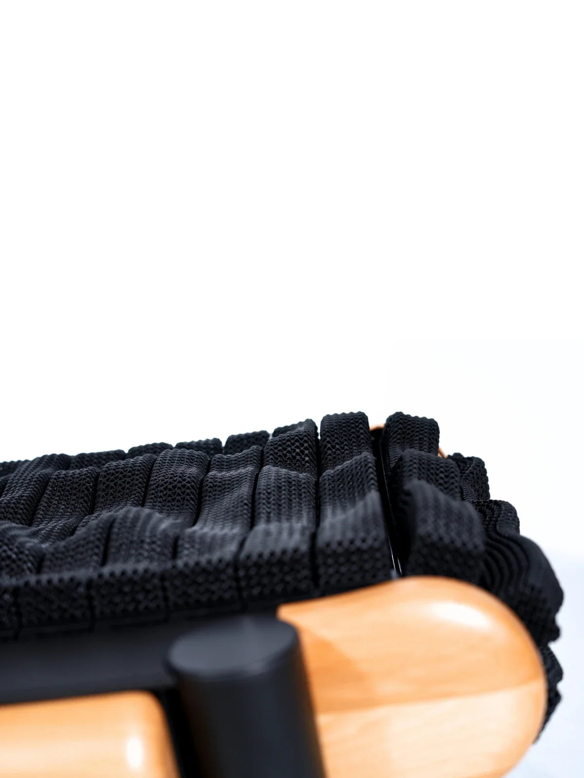 Close-up of the TheraFloor® Home Upgrade-Kit for Walkolution 1, featuring a seat with black woven straps and a light wooden frame. The textured design offers ergonomic support reminiscent of a cushioned treadmill mat, combining style and comfort.