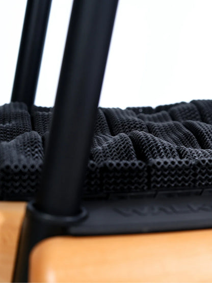 Close-up of the TheraFloor® Home Upgrade-Kit for Walkolution 1, showing its black woven seat supported by two black metal legs and a wooden frame with an anti-fatigue surface texture.