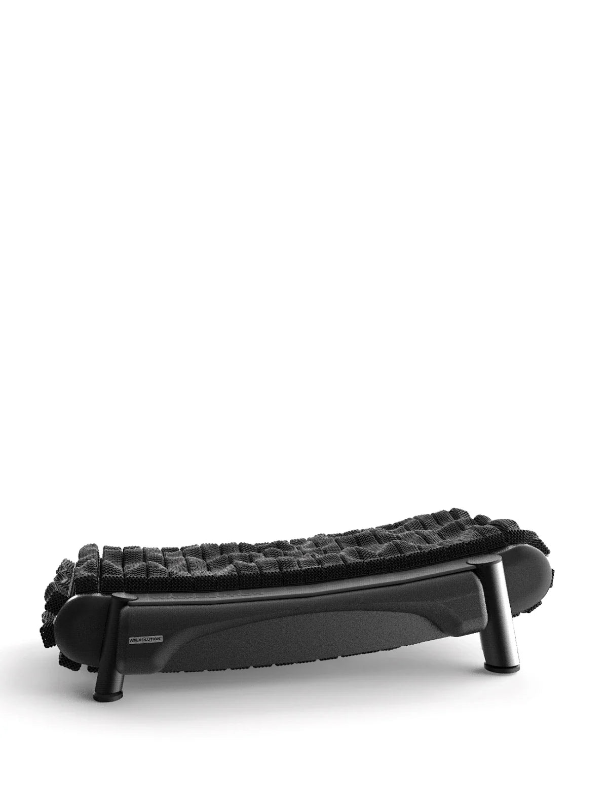 The Walkolution 2, a black ergonomic footrest with a textured, cushioned surface and curved design on four short legs, is ideal for use with a manual office treadmill for walking while you work. Shown against a plain white background.