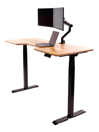 The Walkolution Core Desk is an L-shaped, height-adjustable desk with a solid beech wood surface, black frame, and integrated monitor arm supporting a screen above a laptop, shown against a white background.